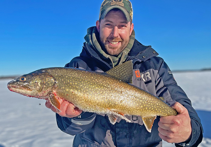 image of ice fisherman holding big Lake Trout caught in the Boundary Waters Canoe Area